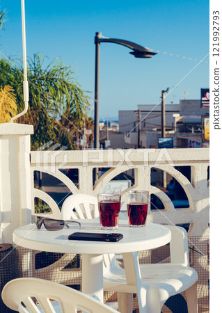 White table with glasses on it and blue sky on a balcony 121992793