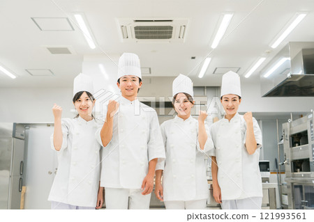 Chefs and cooks in chef coats standing in the kitchen Chefs and cooks in chef coats standing in the kitchen 121993561