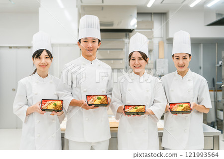 Chefs and cooks in chef coats standing in the kitchen Chefs and cooks in chef coats standing in the kitchen 121993564