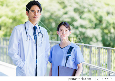 Doctor and nurse talking in a hallway of a medical facility 121993602