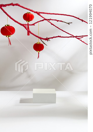 Overhead view of an empty white rectangular platform on a white background. Crimson lanterns swing from branches covered with red fabric. The Lunar New Year products advertisement photo. Overhead view of an empty white rectangular platform on a white background. Crimson lanterns swing from branches covered with red fabric. The Lunar New Year products advertisement photo. 121994070