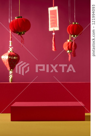 A classic idea for the New Year. A product is displayed on empty red cylindrical pedestals, standing on a golden surface in front of a crimson backdrop. Adorned with calligraphy and Chinese lanterns. A classic idea for the New Year. A product is displayed on empty red cylindrical pedestals, standing on a golden surface in front of a crimson backdrop. Adorned with calligraphy and Chinese lanterns. 121994093