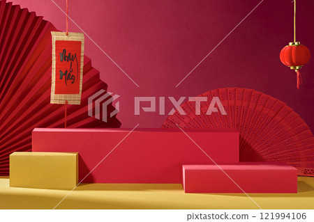 A frontal view of some empty rectangular platform, with red hand fans, Chinese lanterns, and calligraphy hanging on a crimson background. A product advertisement with a traditional New Year theme. A frontal view of some empty rectangular platform, with red hand fans, Chinese lanterns, and calligraphy hanging on a crimson background. A product advertisement with a traditional New Year theme. 121994106