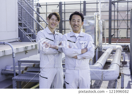 兩名穿著工作服的男子站在屋頂給排水設備前攝影合作:電波學園教育法人東京電子學校。 兩名穿著工作服的男子站在屋頂給排水設備前攝影合作:電波學園教育法人東京電子學校。 121996082