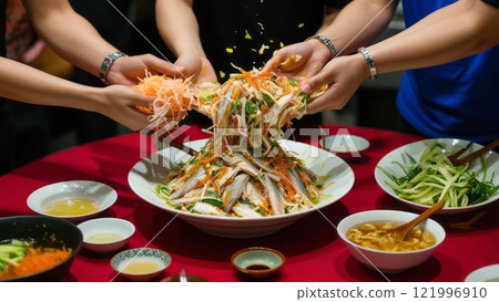 Hands tossing vibrant Asian salad for celebration 121996910