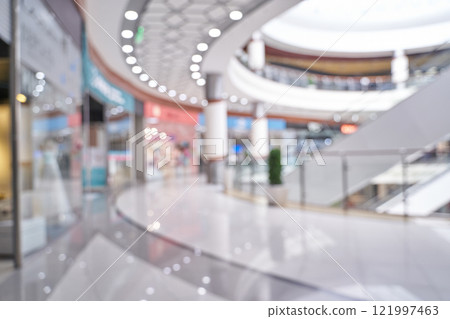 Modern shopping mall interior with blurred storefronts and elegant architecture Modern shopping mall interior with blurred storefronts and elegant architecture 121997463