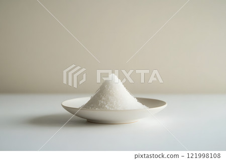 Mound of salt. Mound of salt. Close-up of a pyramid of refined salt on a white plate. Mound of salt. Mound of salt. Close-up of a pyramid of refined salt on a white plate. 121998108