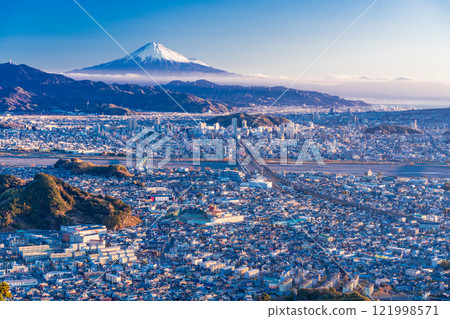 [Shizuoka Prefecture] Mount Fuji over the Shizuoka cityscape shining with the morning sun shining through 121998571