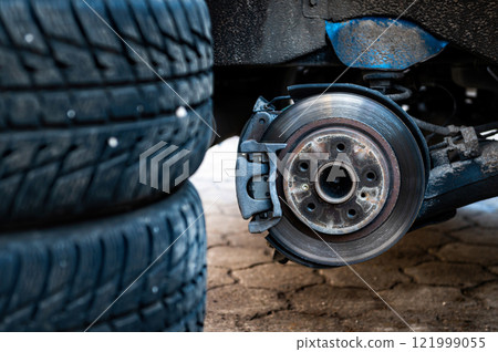 winter tires next to the car, seasonal tire change concept, selective focus, focus on car, close-up winter tires next to the car, seasonal tire change concept, selective focus, focus on car, close-up 121999055
