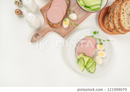 Breakfast Sliced boiled ham sausage and boiled egg on a light background, top view. copy space Breakfast Sliced boiled ham sausage and boiled egg on a light background, top view. copy space 121999070