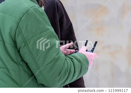 area planners survey the surroundings with a drone, close-up of hands with a drone remote controller area planners survey the surroundings with a drone, close-up of hands with a drone remote controller 121999117