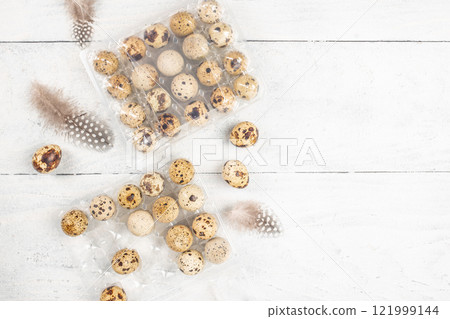 Quail eggs in container on a light wooden background. Easter celebration concept top view 121999144