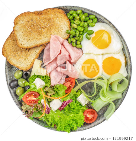 Plate of breakfast with fried eggs, ham and salad isolated on white background. top view 121999217