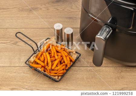 crispy sweet potato for air fryer oven on a wooden background, Diet French fries 121999258