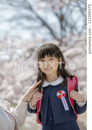 一年級學生背著書包享受櫻花公園 121999378