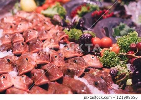 Colorful arrangement of fish and vegetables in a market 121999656