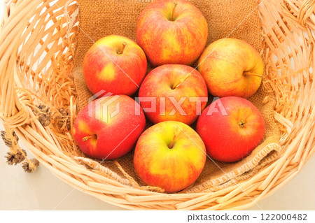 Apples in a straw basket. Orange ripe fruits. Apples can be used as raw materials for making jams, jellies, and mousses. 122000482