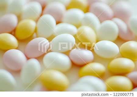 Colorful assortment of candy-coated eggs scattered on a light surface during spring festivities Colorful assortment of candy-coated eggs scattered on a light surface during spring festivities 122000775