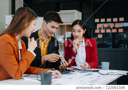 Business team working on a project in the office or reviewing and discussing a business project. 122001306