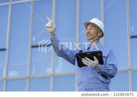 一名60多歲的工人正在檢查建築物 122001675