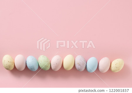Easter frame with pastel decorative colorful eggs in raw on pink background. View from above. Flat lay. DIY. Happy spring greeting card with copy space. Easter frame with pastel decorative colorful eggs in raw on pink background. View from above. Flat lay. DIY. Happy spring greeting card with copy space. 122001837