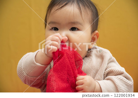 Baby sitting on a yellow background 122001934