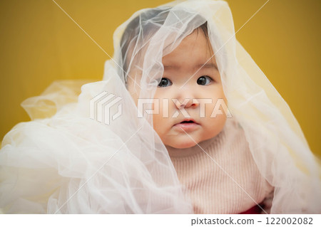 黃色背景中坐著一個淚眼汪汪的嬰兒 122002082