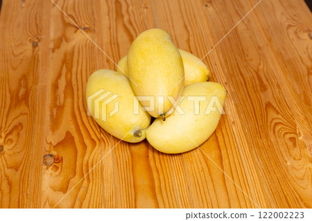 Fresh sliced, cut, diced ripe mango on gray table background with leaf for eating. 122002223