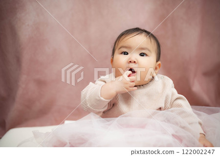 Baby sitting on a pink background 122002247