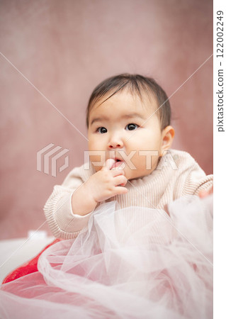 Baby sitting on a pink background Baby sitting on a pink background 122002249