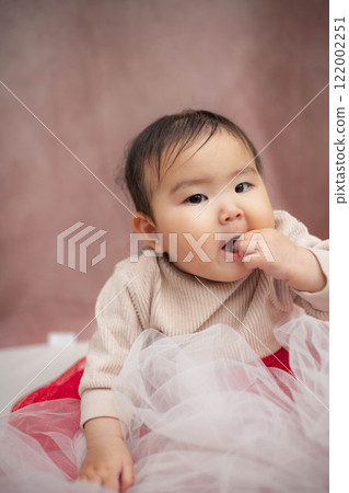 嬰兒坐在粉紅色的背上 嬰兒坐在粉紅色的背上 122002251