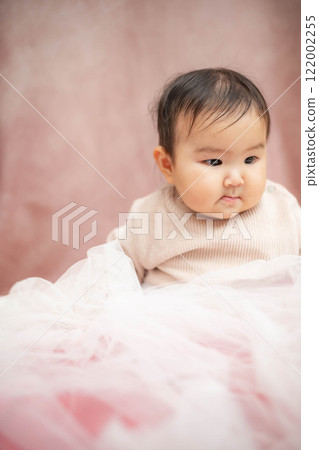 Baby sitting on a pink background 122002255