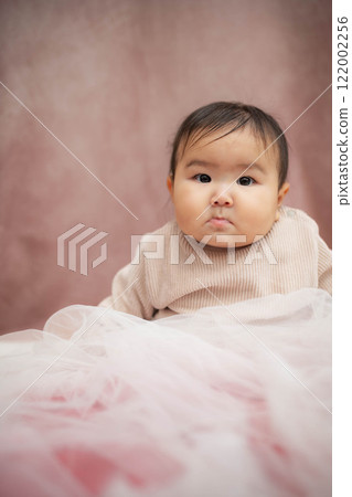 Baby sitting on a pink background Baby sitting on a pink background 122002256