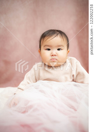 Baby sitting on a pink background Baby sitting on a pink background 122002258