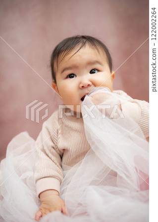 嬰兒坐在粉紅色的背上 嬰兒坐在粉紅色的背上 122002264