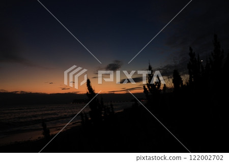A view of Enoshima and the orange sunset from Shichirigahama Beach in Kamakura - Evening scenery A view of Enoshima and the orange sunset from Shichirigahama Beach in Kamakura - Evening scenery 122002702