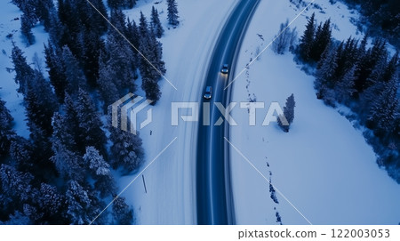 Aerial view of winter road with cars through snowy forest 122003053
