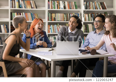 Laughing diverse young people relax from learning at public library Laughing diverse young people relax from learning at public library 122003247