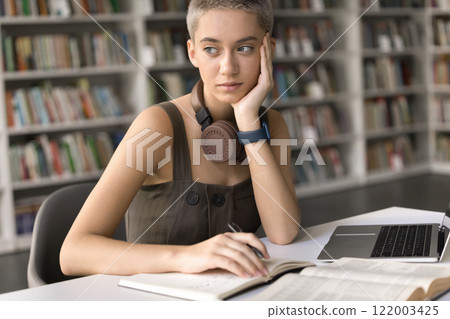 Pensive teen girl student study at library look aside think Pensive teen girl student study at library look aside think 122003425