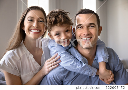 Happy couple of parents and son child sitting close together Happy couple of parents and son child sitting close together 122003452
