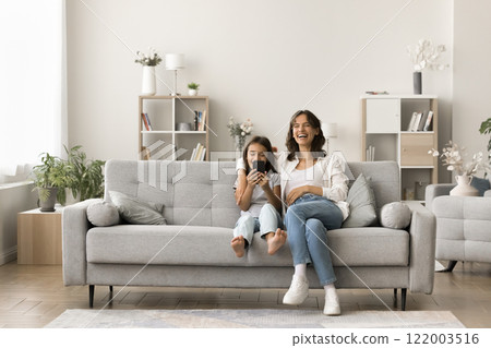 Laughing woman her little 6s daughter using modern smartphone 122003516