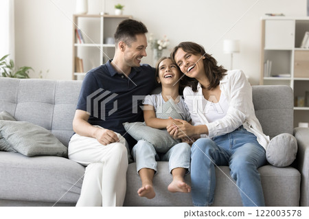 Family with daughter enjoy talk seated on sofa at home 122003578