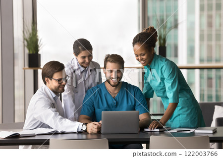 Smiling clinic staff members using laptop at workplace Smiling clinic staff members using laptop at workplace 122003766