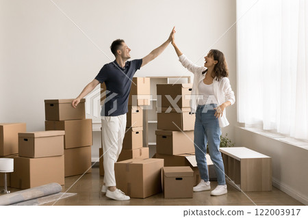 Young couple giving high-five gesture, celebrating relocation day Young couple giving high-five gesture, celebrating relocation day 122003917
