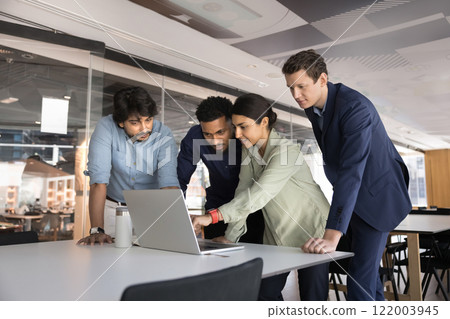 Multiethnic business team of young colleagues standing at laptop Multiethnic business team of young colleagues standing at laptop 122003945