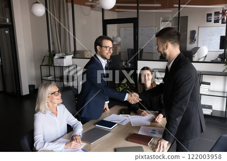 Group of shareholders greeting each other before negotiations in boardroom Group of shareholders greeting each other before negotiations in boardroom 122003958