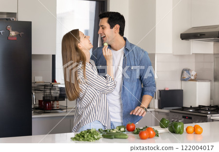 Young couple cooking healthy vegan salad from fresh organic food 122004017