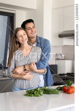Happy attractive Latin married couple enjoying cooking hobby 122004055