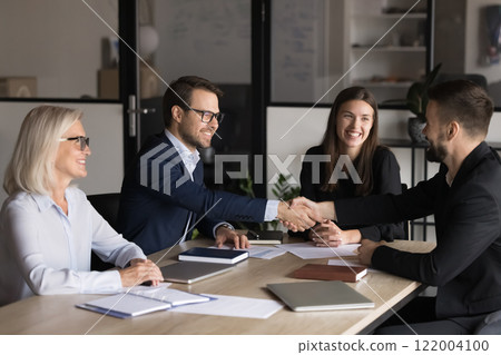 Two business parties shaking hands greeting each other start negotiations 122004100