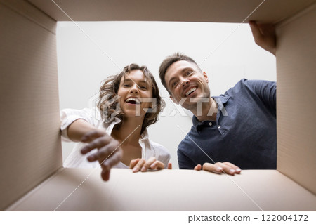 Happy couple getting long awaited parcel, cardboard box bottom view 122004172